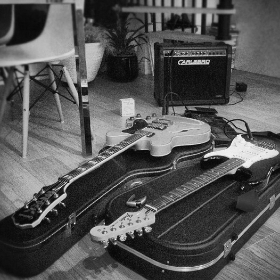 Two electric guitars placed on cases on wooden floor