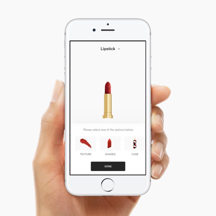 Hand holding mobile device with Carolina Herrera makeup configurator